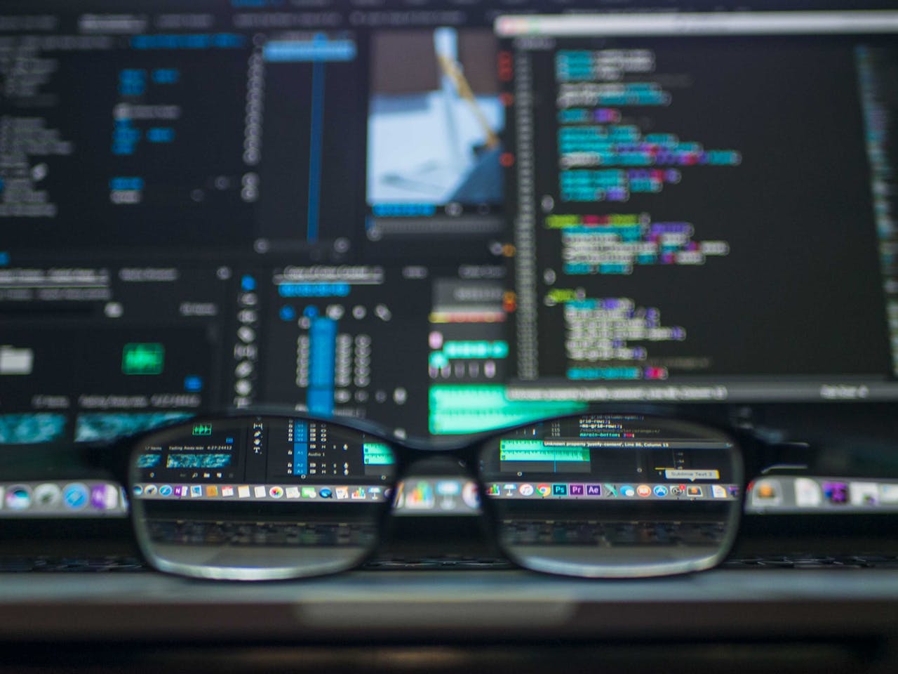 who-we-are-img Eyeglasses reflecting computer code on a monitor, ideal for technology and programming themes.